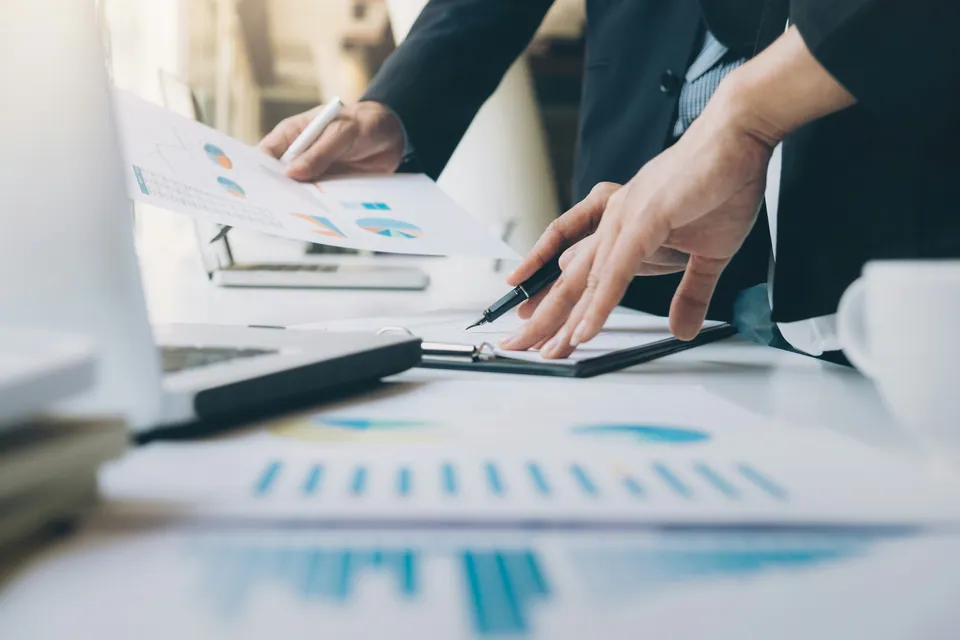 Colleagues reviewing printed charts on a desk