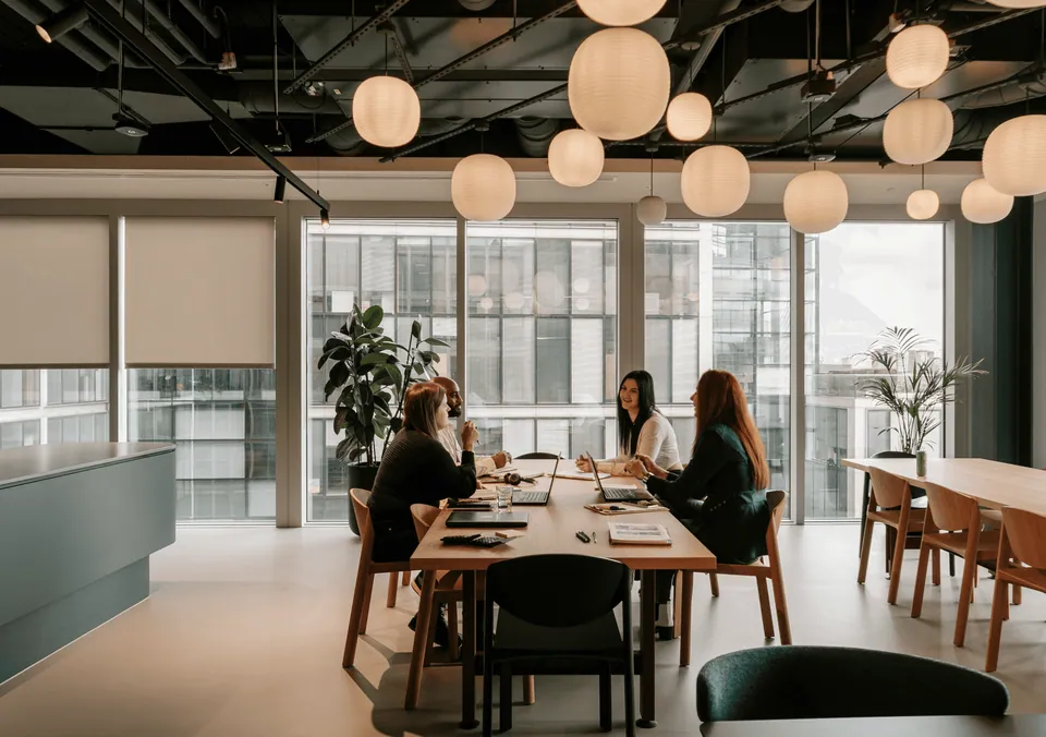 Modern office with pendant lights and people at a long table