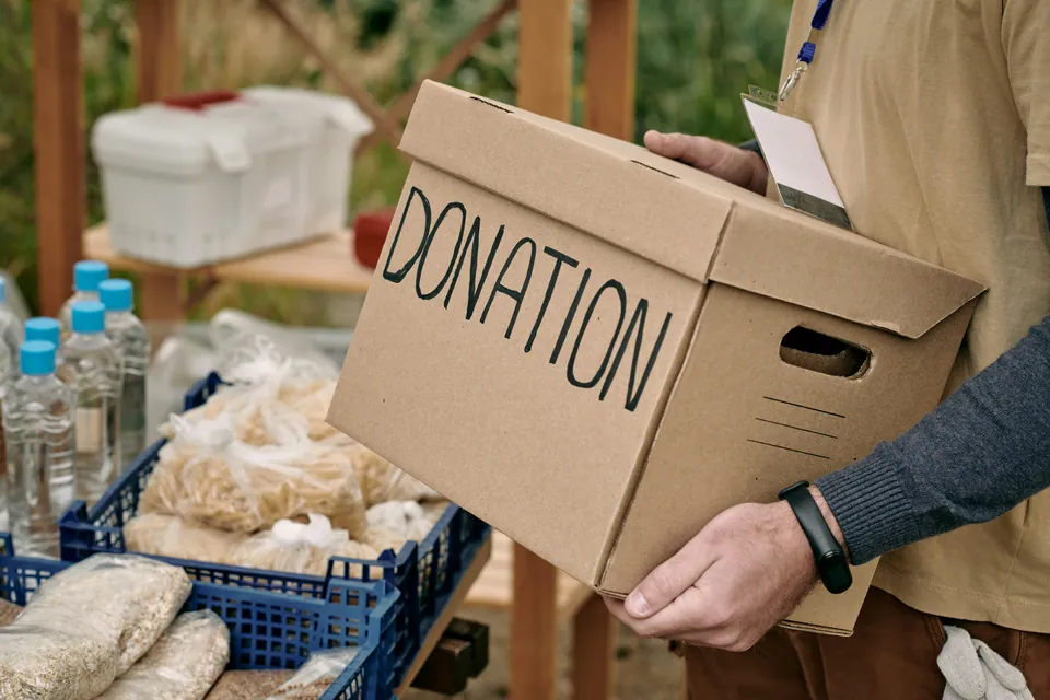 Volunteer carrying a cardboard donation box